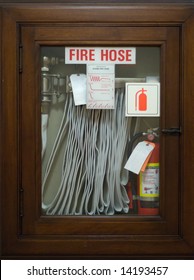 An emergency fire hose enclosed behind glass