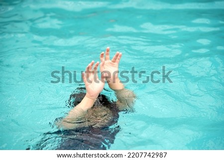emergency kid drowing in swimming pool show up two hand call for help