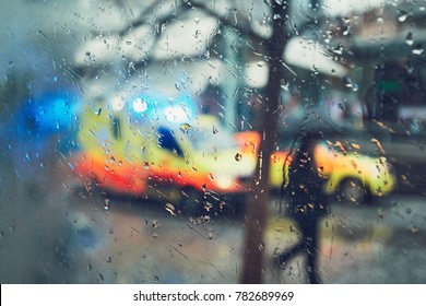 Emergency Medical Service Response In The City. Ambulance Cars On The Rush Street During Rain. View Through A Car Window And Selective Focus On The Raindrop. Prague, Czech Republic.