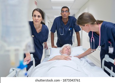 Une équipe médicale d'urgence fait rouler le patient le long du couloir de l'hôpital : photo de stock