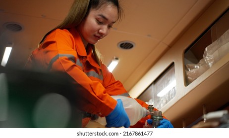 Emergency Medical Technician (EMT) Asian Woman Or Paramedic Giving Emergency Oxygen With Patient In Ambulance Car