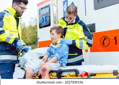 Emergency medics taking care of injured boy with whiplash - Powered by Shutterstock