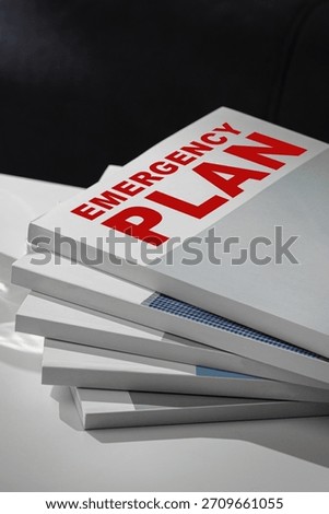 Emergency plan documents stacked on a desk for quick reference in crisis situations