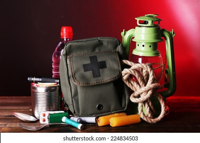 Emergency Preparation Equipment On Wooden Table, On Dark Background