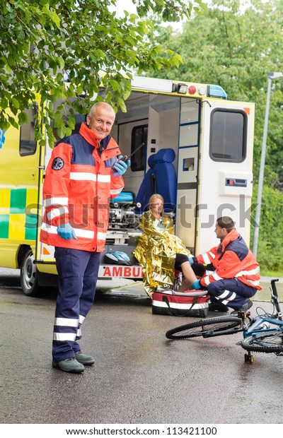 Emergency radio calling paramedics helping\
woman bike accident\
ambulance