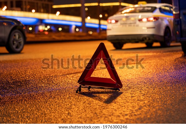 emergency stop sign\
at night, car breakdown, car stopping on the edge of the road at\
night, selective focusing, image tinting, illumination and glare in\
the camera from the\
lights
