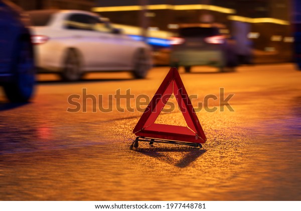 emergency stop sign\
at night, car breakdown, car stopping on the edge of the road at\
night, selective focusing, image tinting, illumination and glare in\
the camera from the\
lights