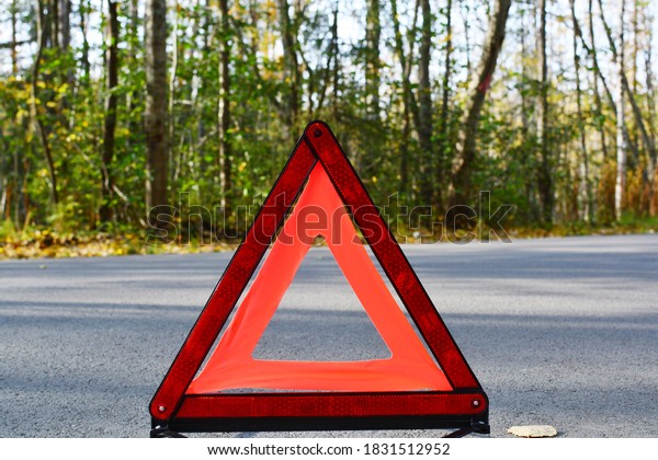 emergency stop sign on the background of the road
and forest. concept of roadside assistance, travel incidents, car
repair. copy space.