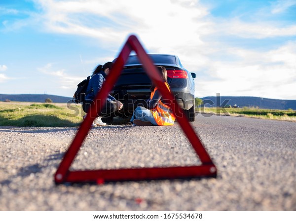 \
emergency\
triangle people on the road by damaged\
car