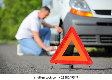 Emergency Triangle Stop Sign And Man Near Broken Car On Road