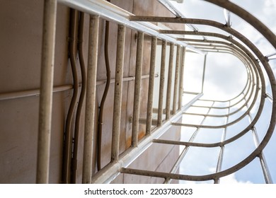 An Emergency Way Climbing Ladder With Falling Prevetion Cage At The Outside Of Factory Building. Industrail Equipment Object Photo, Selective Focus At Some Rail Step.