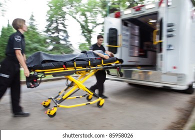 Emergency Workers Rushing Senior Woman Into An Ambulance