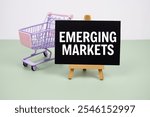 Emerging Markets text message and trolley shopping cart on green background