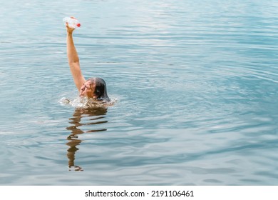 Emerging From Water Person Success Man Winning Moment. Save Ocean Plastic Pollution. Arm Raised Hand Holding Bottle Plastic Garbage Beach Pollution. Motivation Concept Hand Trash Beach. Effort Concept