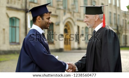 Eminent professor giving diploma to male student shaking hand, successful future