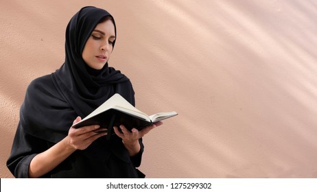 Emirati Arab Girl Reading The Notebook Wearing  Traditional Middle Eastern Women Dress