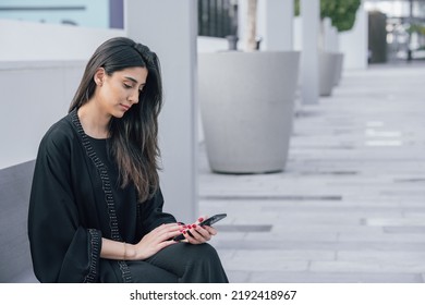 Emirati Business Woman On Her Phone Outdoor Working Or Chatting Wearing Abaya 