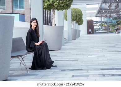 Emirati Business Woman Working Or Chatting On Her Phone Outdoor Wearing Abaya