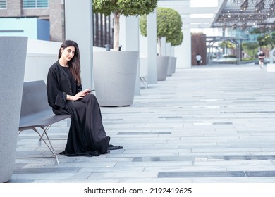 Emirati Business Woman Working On Her Phone Smiling Wearing Abaya Outdoor 