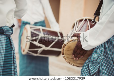 Emirati locals (GCC /Gulf) celebrating, dancing and playing traditional music and drumming in old drums in one of their culture occasion and wearing local kandura, happy with emirati yola dance.