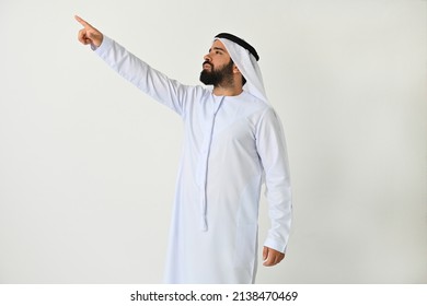 Emirati man pointing finger to side in UAE showing or presenting an offer or looking at something far