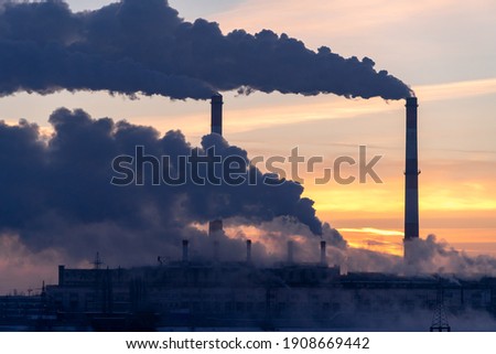 Emission to atmosphere from industrial factory chimney. Smokestack pipes shooted with drone. Global warming concept and air pollution. Aerial view.