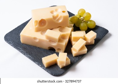 Emmental Cheese Cut And Grapes On A Slate Table