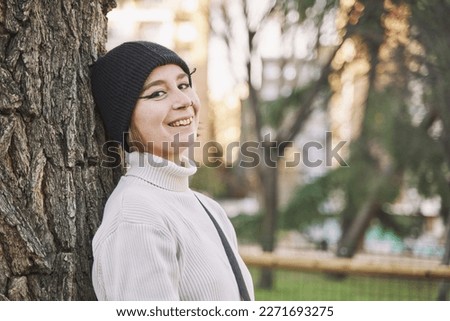 emo woman wearing a wool hat and turtleneck sweater looking at the camera