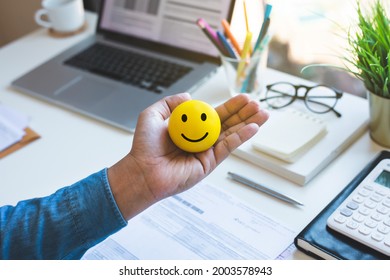 Emoticon ball on male hand on work table.happy life concepts.inspiration and motivation idea