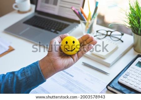 Emoticon ball on male hand on work table.happy life concepts.inspiration and motivation idea