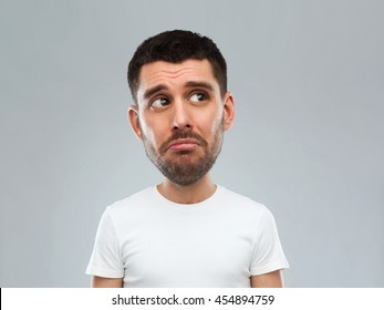 Emotion, Facial Expressions And People Concept - Sad Young Man In White T-shirt Over Gray Background Looking Up (funny Cartoon Style Character With Big Head)