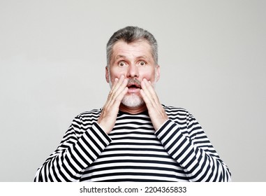 Emotion, Lifestyle And Old People Concept: Portrait Senior Bearded Man, Looking Shocked, Scared Trying To Protect Himself In Anticipation Of Unpleasant Situation, Isolated On Grey Background.