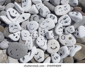 Emotion management concept, stones with painted faces symbolize different emotions. We are all different, but all together, learning to manage emotions. Emotional intelligence, role model. Good mood. - Shutterstock ID 1944994009