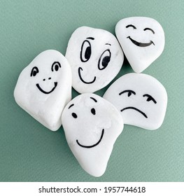 Emotion management concept, stones with painted faces symbolize different emotions. Funny, sad, curious, surprised, happy faces on green background. Emotion management learning, socialization - Shutterstock ID 1957744618