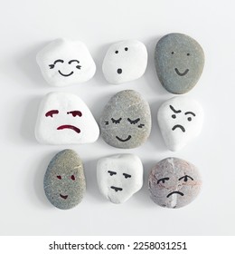 Emotion management concept, stones with painted faces symbolize different emotions. HRM or Human Resource Management.  Learning to manage emotions. One team called humanity. - Shutterstock ID 2258031251