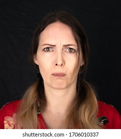 Emotion Resentment. Closed Portrait Of Woman Face With Facial Expressions Over Black Background. One Photo From A Series