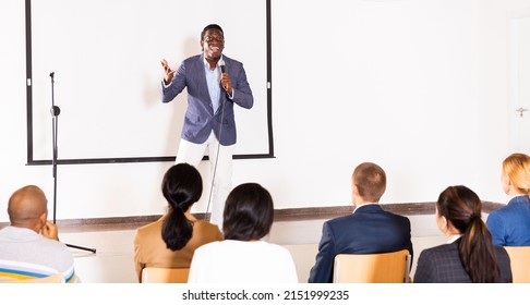 Emotional aframerican business coach giving motivational training for group of businesspeople, speaking from stage in conference room - Powered by Shutterstock