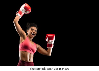 Emotional african american girl boxer celebrating success over black studio background, empty space - Powered by Shutterstock