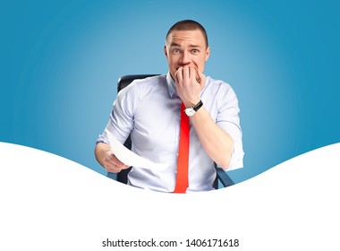 Emotional And Ambitious Young Leader Sits At The Table And Works With Documents And Papers. On A Blue Background Studio Photography