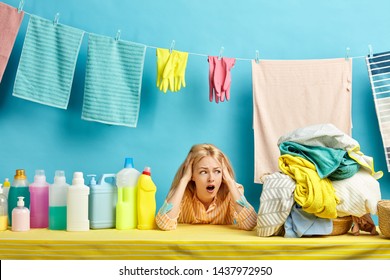 emotional blonde woman is in panic as she doesn't want to wash clothes by hand, he washing machine has broken. lazy girl hates laundry process