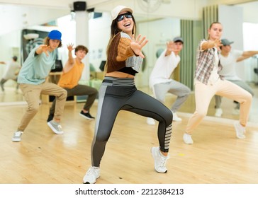 Emotional Brunette Teen B-girl Dancing With Group Of Friends In Dance Studio. Hip-hop Generation.