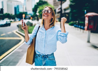 Emotional businesswoman in smart casual wear expressing happiness getting good job offer on mail. Excited female holding mobile celebrating received opportunity via online message on mobile phone - Powered by Shutterstock