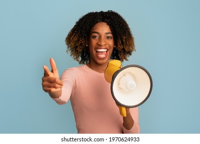 Emotional Cheerful Black Woman Making Announcement With Megaphone In Hands, Positive African American Lady Sharing News Or Interesting Offer, Standing Over Blue Studio Background, Copy Space