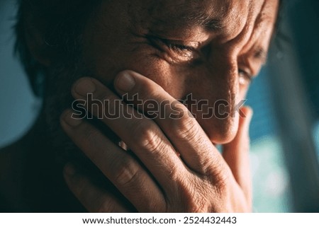 Emotional distraught sad man crying stressed, dealing with mental health problems, depression, anxiety and despair, selective focus