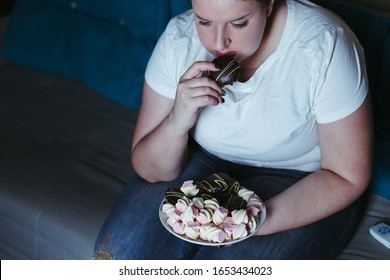 Emotional Eating, Mental Disorder, Depression, Loneliness, Stress. Lonely Woman Eating Sweets And Watching Tv Late In The Night. Nerve Food