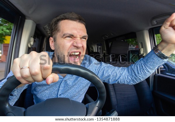 Emotional evil person. The driver of the car\
screams at someone in the traffic jam. Concept hysterics and broken\
car, road repair