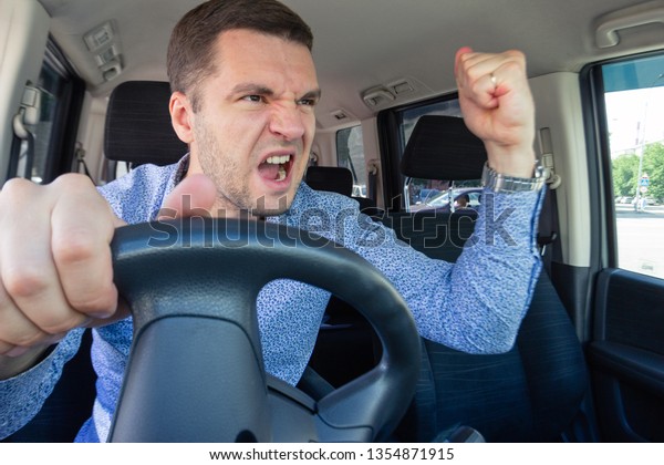 Emotional evil person. The driver of the car\
screams at someone in the traffic jam. Concept hysterics and broken\
car, road repair