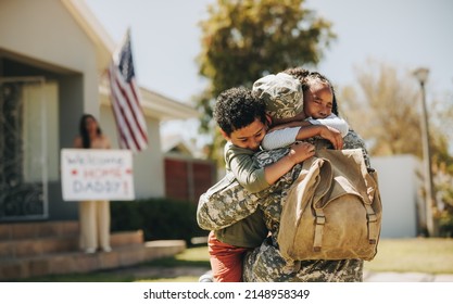 Emotional family reunion. Military dad embracing his children after returning home from the army. American soldier receiving a warm welcome from his family after serving in the military. - Powered by Shutterstock