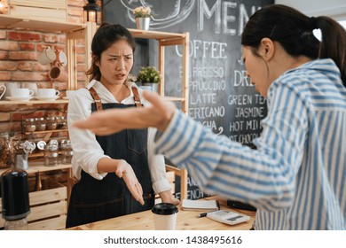 Emotional Female Customer Arguing With Staff Girl At Bar Counter. Unsatisfied Visitor Angry About Service In Cafe Shop. Woman Client Dislike Coffee Drink And Yelling At Barista Lady In Morning Store