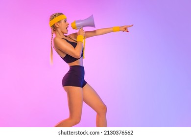 Emotional fit woman in sportswear screaming using megaphone. Social issues, protest concept. Side view. A girl speaks into a megaphone about an upcoming promotion and discounts in fitness store - Powered by Shutterstock